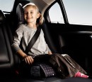 Child wearing seat belt on booster seat