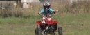 Five-year-old kid driving an ATV on private field