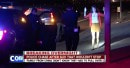 Chinese tourist holds hands up as police officers point guns at her