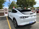 Ford Mustang Mach-E charging at a Tesla Supercharger station