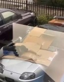 Owner desperately tries to protect his Toyota Supra from the hail, using his body as shield