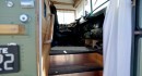 School bus transformed into a motorhome with a dog crate and a fuctional kitchen