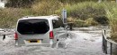Vehicles Going Through a Flooded Ford