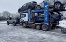 Land Rover Defender 110 comes through on icy road for truck carrying 7 Land Rovers