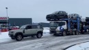 Land Rover Defender 110 comes through on icy road for truck carrying 7 Land Rovers