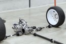 Gearbox, front differential, and transfer case of Puma Rally1 racecar, complete with halfshafts, driveshaft, and wheels