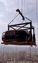 Brand new Rolls-Royce Ghost is craned 44 floors up to be used as static display on the terrace of a condo