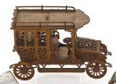 An Art Nouveau fretwork cigar box, circa 1905, ornately carved in the fashion a vintage limousine, hinged roof raises to reveal cigar storage.