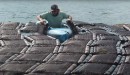 farmworker flipping the oyster bags manually from a kayak