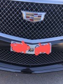 Cadillac replaces mandatory front license plate with sticker to "improve performance"