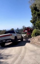 The Rivian R1T pulls a heavy truck out of a ditch
