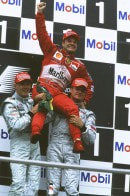 McLaren's Mika Hakkinen and David Coulthard lift Rubens Barrichello in celebration of his maiden F1 win, in the 2000 German GP