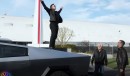 Elon Musk jumps up on the tonneau of the Cybertruck