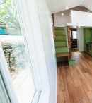This custom tiny house invites nature in and creates a very personalized space by using bright colors