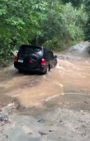 Mitsubishi Pajero attempts crossing of swollen, fast stream, fails terribly