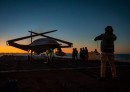 A Boeing unmanned MQ-25 aircraft is given operating directions on the flight deck aboard the aircraft carrier USS George H.W. Bush