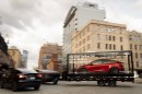 The Tesla Cybertruck is towing a trailer with the Model Y on it in New York City