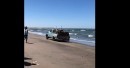 Vintage Ford truck captured exiting the ocean with wood load