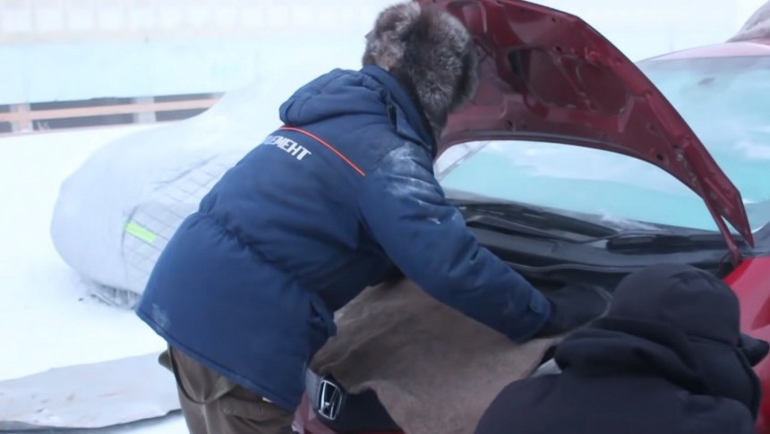 Placing a blanket on the engine of a Honda Jazz/Fit