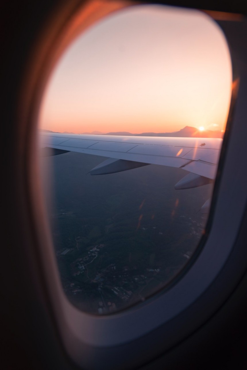 Sunset over airplane wing in flight