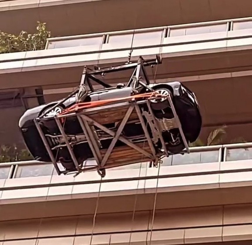 A brand new Rolls-Royce Ghost is hoisted by crane to the 44th floor for use as a static display on an apartment terrace