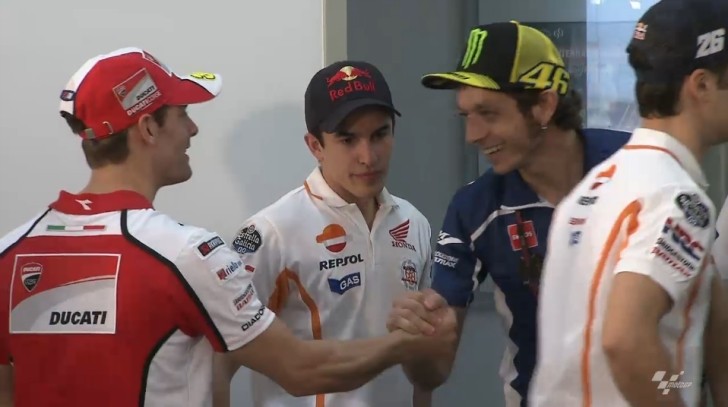 MotoGP riders at a press conference in Qatar. Rossi shakes hands with Crutchlow