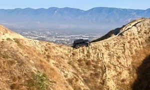 A Jeep Wrangler Is Hanging Off a Mountain Ridge, on a Narrow Bike Trail