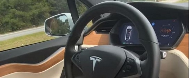 Model X drives itself on the highway in heavy traffic, with driver in the passenger seat