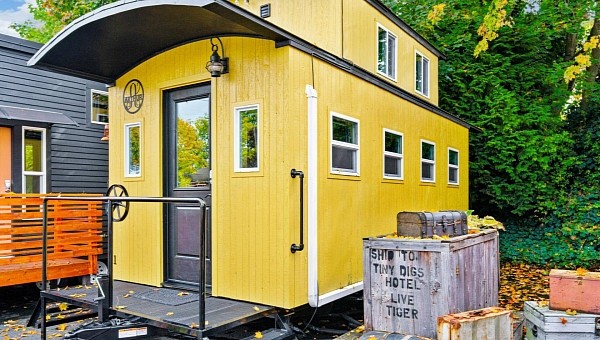 Arthur is a tiny house inspired by a caboose car, offering sleeping for four people