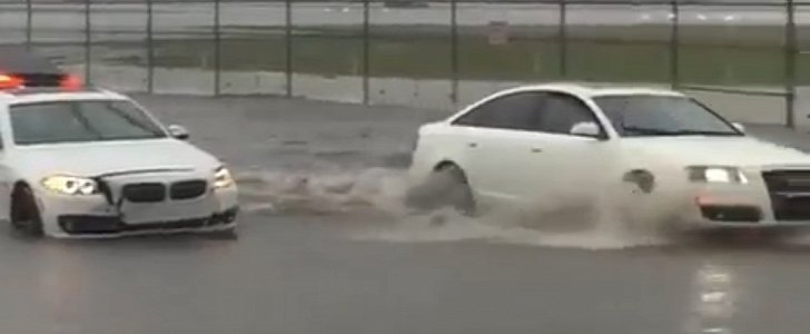 Older Audi A6 drives through water while passing flooded BMW 5 Series