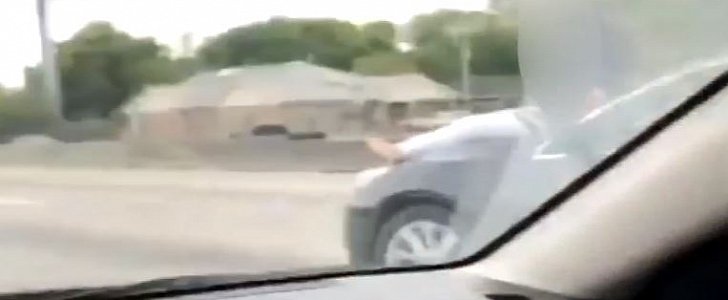 Barefoot woman rides on hood of the car in Houston, Texas