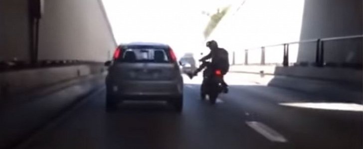 Biker kicks car in Brazil, topples over immediately