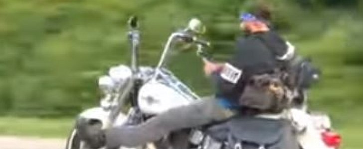 Biker rides hands-free while checking his phone, at highway speed