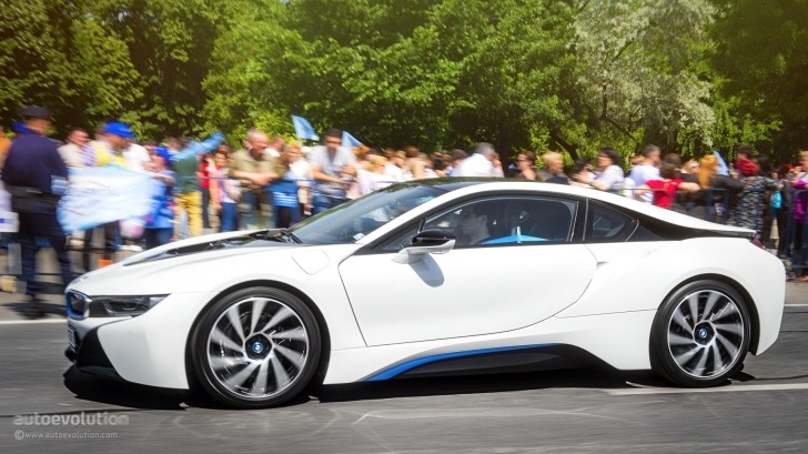 BMW i8 driving through protest