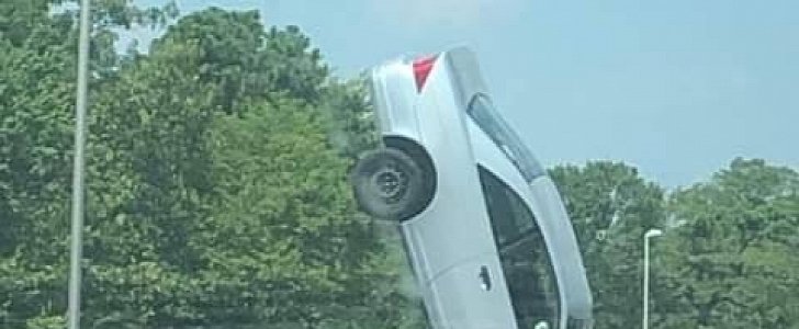 2-vehicle crash ends with one car on its nose, perpendicular in the air