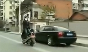 Chinese Rides Scooter Standing Backwards, Talking over Phone