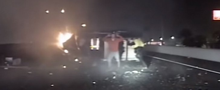 Cops and motorists strive to flip burning car to rescue injured driver