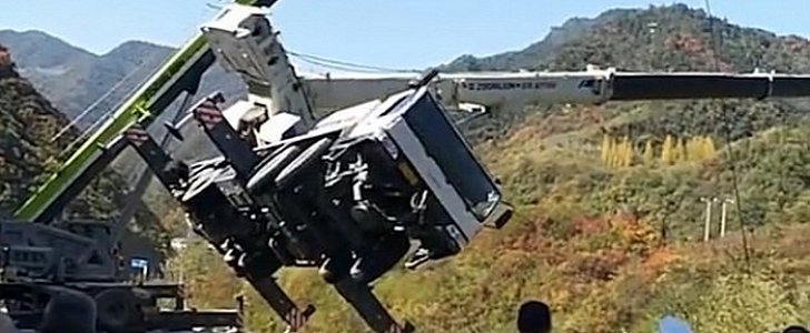 Crane topples over, down a hillside in China
