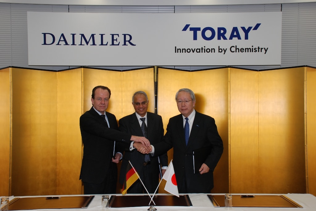 Daimler and Toray execs shake hands after JV contract signing