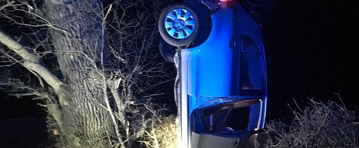 Drunk driver crashes, manages to get car hanging upside down from a tree