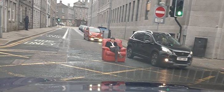 Man chills on leather armchair in the middle of busy street in Aberdeen, Scotland