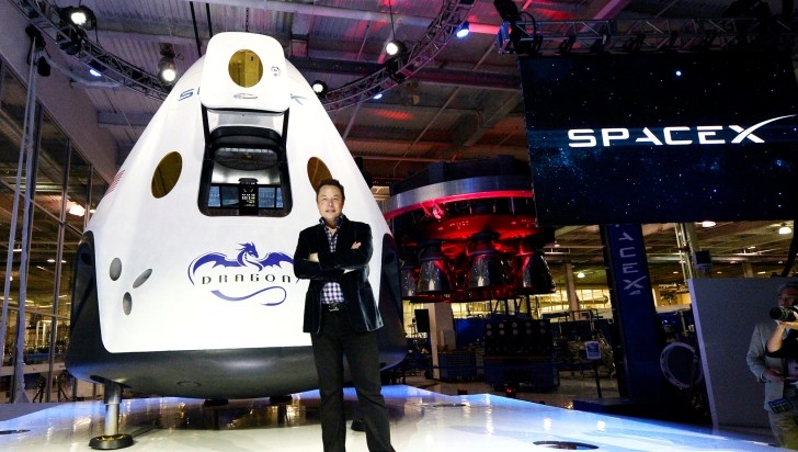 Elon Musk next to his Dragon cargo vehicle
