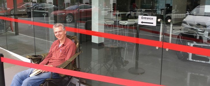 Andreas Stephenson camping in front of Sydney Tesla store