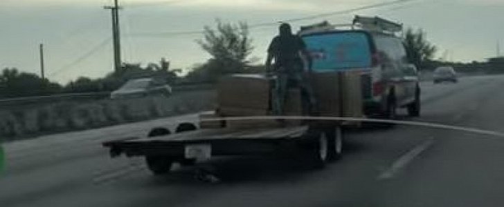 Dude hangs on to load on trailer at 70mph, as a means to secure it