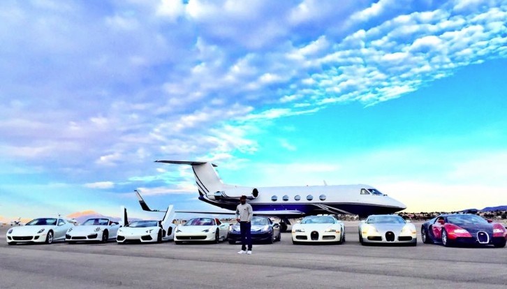 Floyd Mayweather next to his car collection