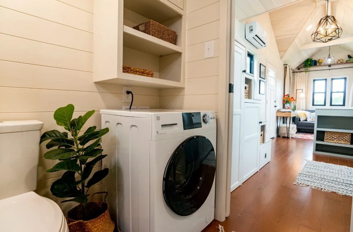 This Tiny House Features a Loft Bedroom and a Living Area With Lots of ...