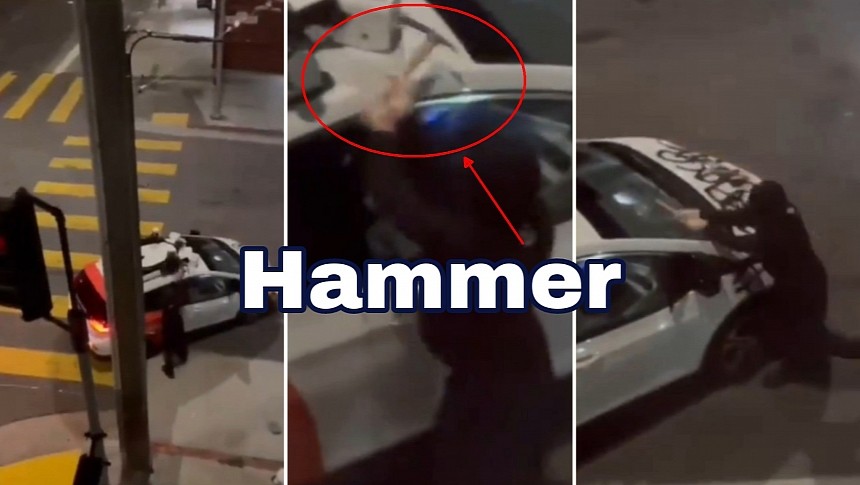 Masked person destroys a Cruise AV with a hammer