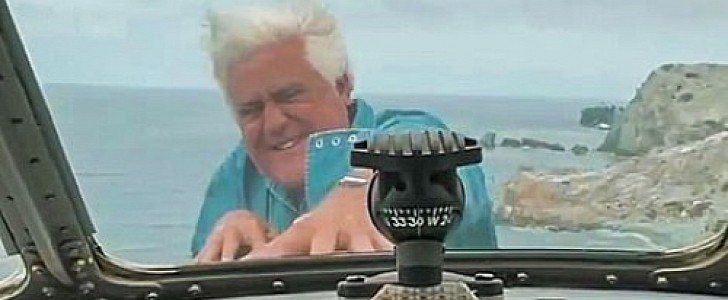 Jay Leno appears to be hanging off the nose of a plane in mid-flight, but he's only standing through a hatch