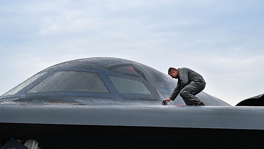 Airman inspecting the fuselage of a B-2 Spirit