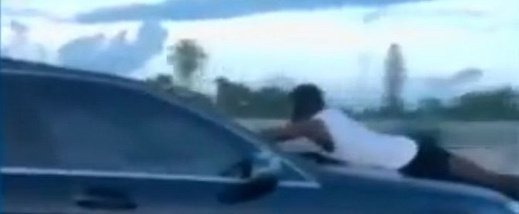 Man clings on the hood of speeding Mercedes while speaking on the phone, as seen on I-95 in Florida